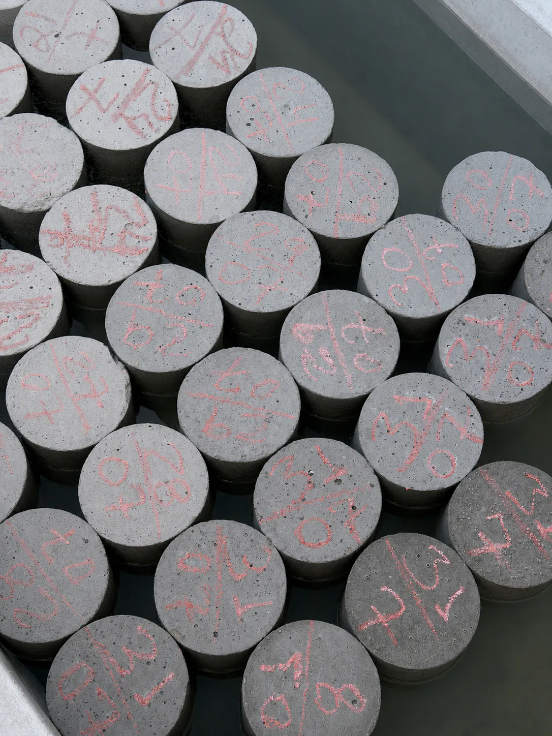 Corpos de prova de concreto em tanque de cura no laboratório da ACT